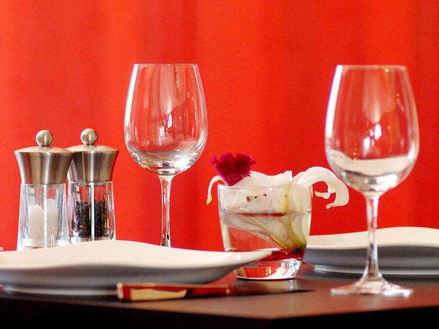 Table de restaurant dressée, prête à recevoir des clients.
